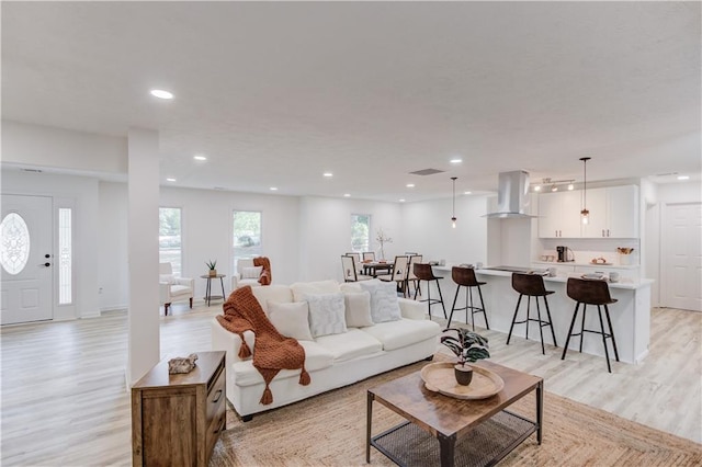 living area with light wood-type flooring and recessed lighting