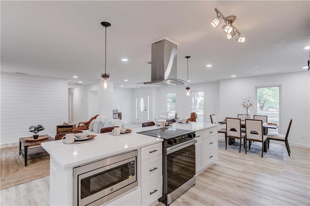 kitchen featuring stainless steel appliances, island exhaust hood, light wood-style flooring, and white cabinets