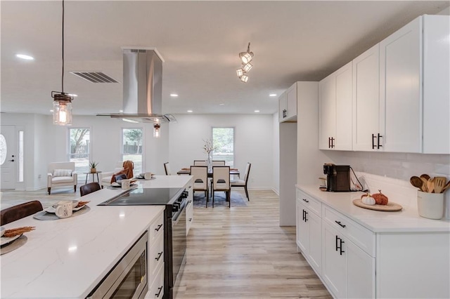 kitchen with visible vents, light wood-style flooring, electric range, white cabinetry, and island range hood