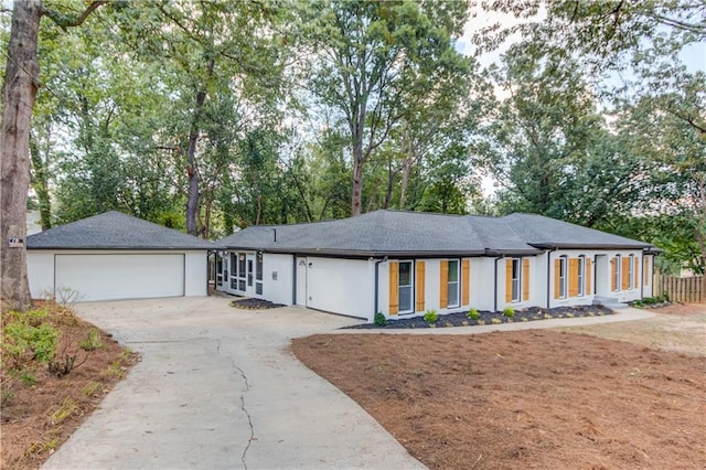 ranch-style house with a garage, driveway, and an outdoor structure