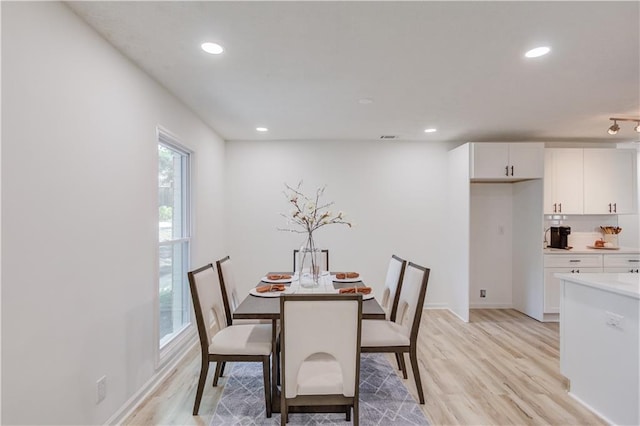 dining room featuring light wood finished floors, baseboards, and recessed lighting