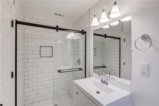 full bath with a stall shower, vanity, and visible vents