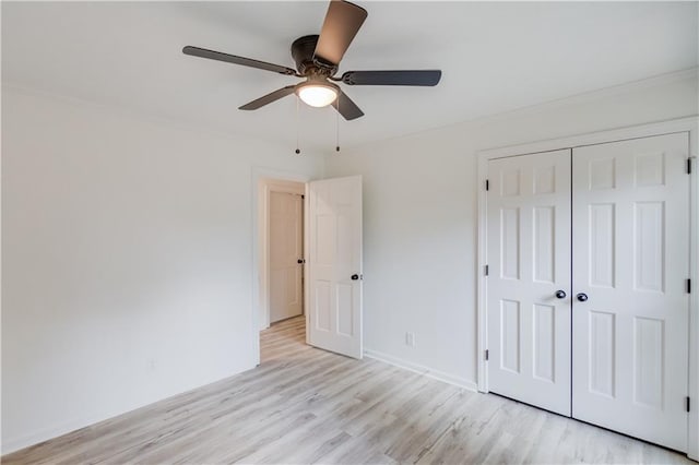 unfurnished bedroom with a closet, ceiling fan, light wood-style flooring, and baseboards