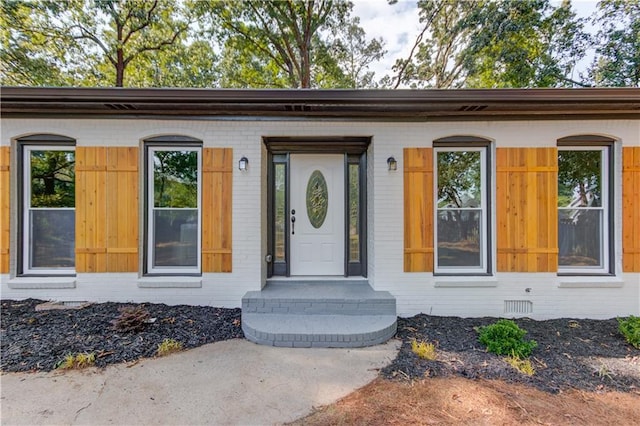 entrance to property with crawl space and brick siding