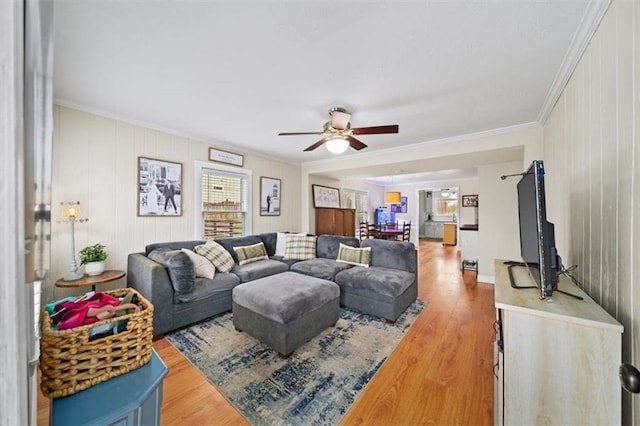 living room featuring ornamental molding, a ceiling fan, and wood finished floors