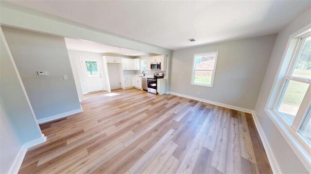 86 Martin Luther King Jr Dr, Jefferson, GA 30549 - unfurnished living room with light wood-type flooring, baseboards, and a sink