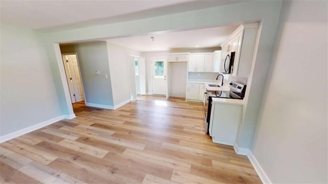 86 Martin Luther King Jr Dr, Jefferson, GA 30549 - kitchen with appliances with stainless steel finishes, white cabinetry, and light wood-type flooring