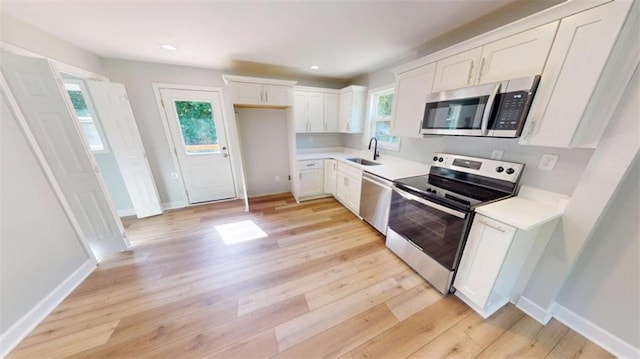 86 Martin Luther King Jr Dr, Jefferson, GA 30549 - kitchen with stainless steel appliances, white cabinetry, a sink, light wood-style floors, and light countertops