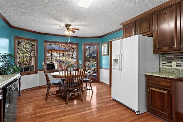 kitchen featuring ceiling fan, dark brown cabinetry, white fridge with ice dispenser, and ornamental molding