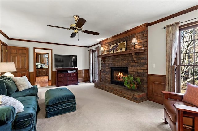 living room featuring ceiling fan, ornamental molding, light carpet, and a brick fireplace