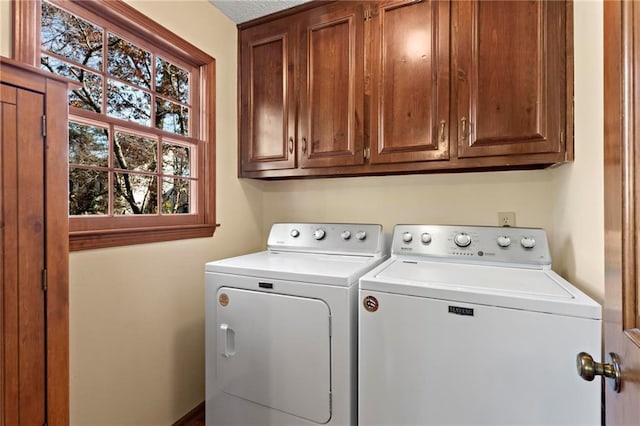 washroom featuring cabinets and separate washer and dryer