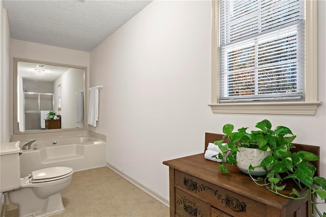 bathroom with a textured ceiling, toilet, and a bathing tub