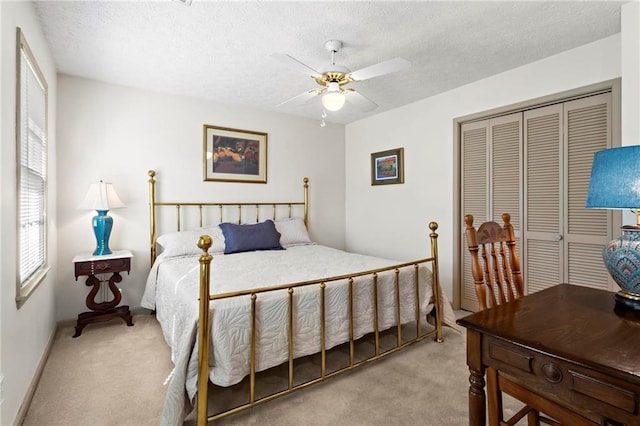 carpeted bedroom with a textured ceiling, a closet, and ceiling fan