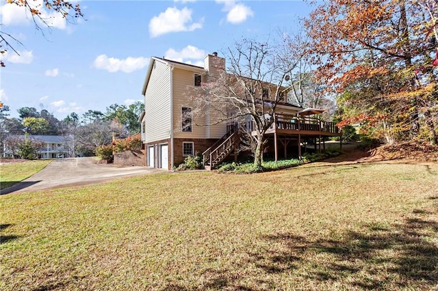 back of property featuring a yard, a garage, and a wooden deck