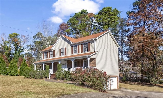 colonial-style house with a porch, a garage, and a front yard