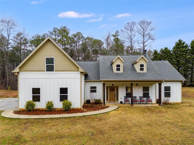 modern farmhouse style home featuring a shingled roof, board and batten siding, and a front yard