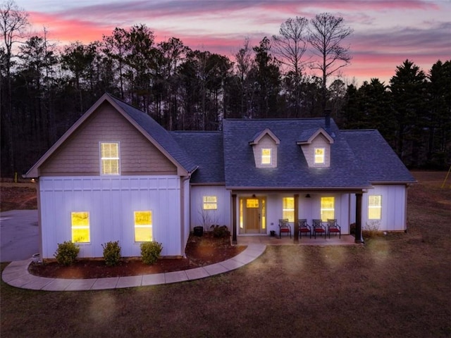 view of front of house featuring a shingled roof, board and batten siding, and a patio area