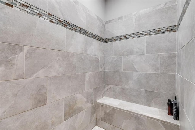 interior details featuring a tile shower