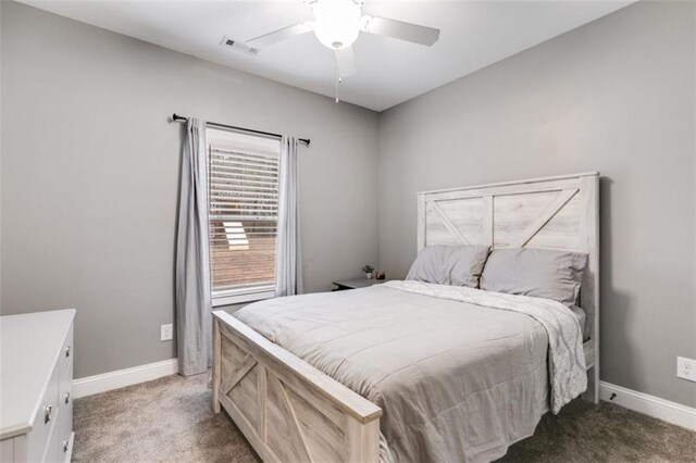 carpeted bedroom with baseboards, visible vents, and ceiling fan