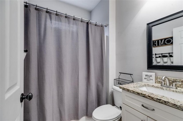 bathroom featuring curtained shower, vanity, and toilet