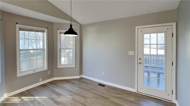 unfurnished dining area with lofted ceiling and hardwood / wood-style flooring