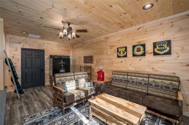 living room with ceiling fan, wood walls, hardwood / wood-style floors, and wooden ceiling