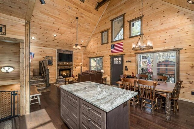 kitchen featuring wood walls, light stone counters, and decorative light fixtures