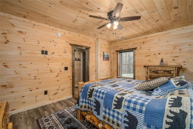 bedroom featuring wood-type flooring, wooden ceiling, wooden walls, and ceiling fan