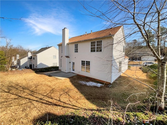 rear view of property with a yard and a patio area