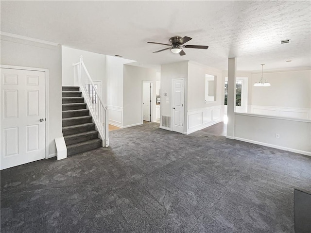 unfurnished living room with ceiling fan with notable chandelier, a textured ceiling, and dark colored carpet