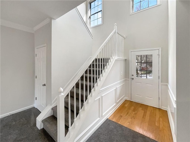 stairs featuring ornamental molding and hardwood / wood-style flooring