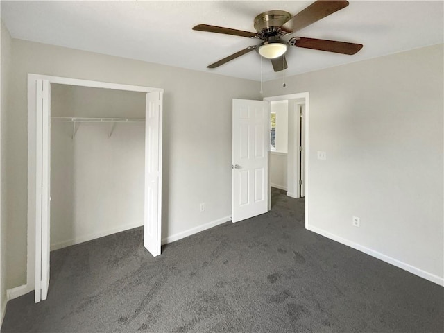 unfurnished bedroom with dark carpet, a closet, and ceiling fan