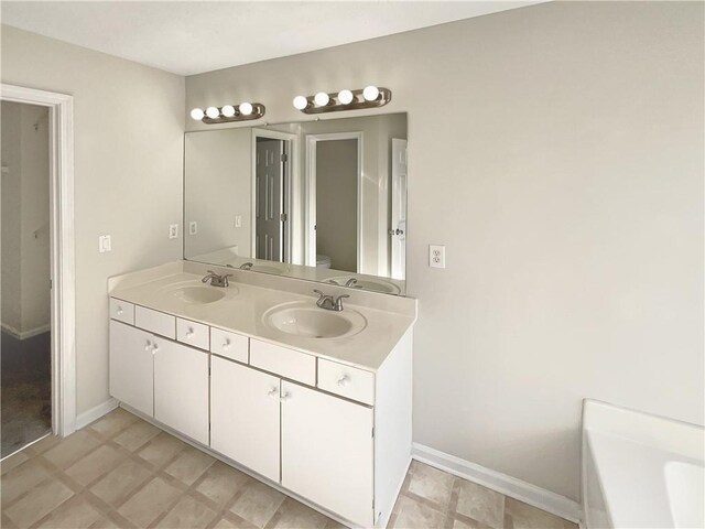 bathroom with toilet, vanity, and a tub to relax in