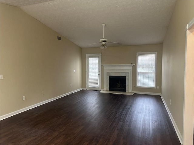 unfurnished living room featuring a high end fireplace, a textured ceiling, vaulted ceiling, and ceiling fan