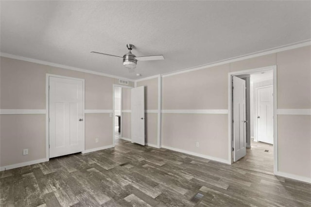 unfurnished room featuring ceiling fan, dark hardwood / wood-style flooring, and ornamental molding