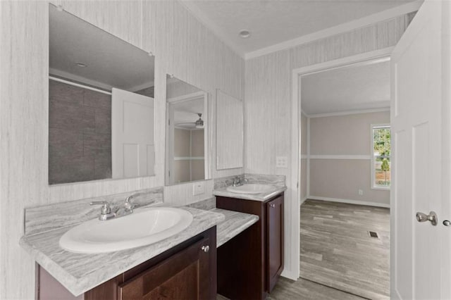 bathroom featuring ceiling fan, crown molding, vanity, and hardwood / wood-style flooring