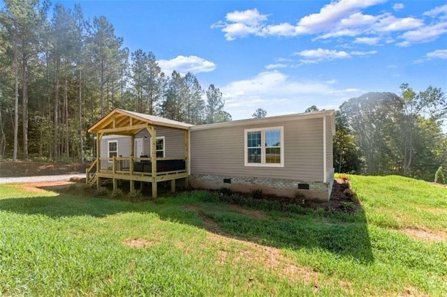 rear view of house with a wooden deck and a lawn