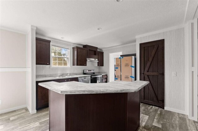 kitchen featuring a center island, stainless steel range with electric cooktop, white fridge, and ornamental molding