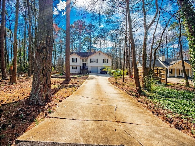 view of front of house with a chimney, concrete driveway, and a garage