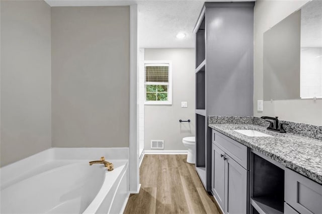 3927 Airline Rd, Mcdonough, GA 30252 - bathroom with vanity, toilet, a garden tub, wood finished floors, and baseboards