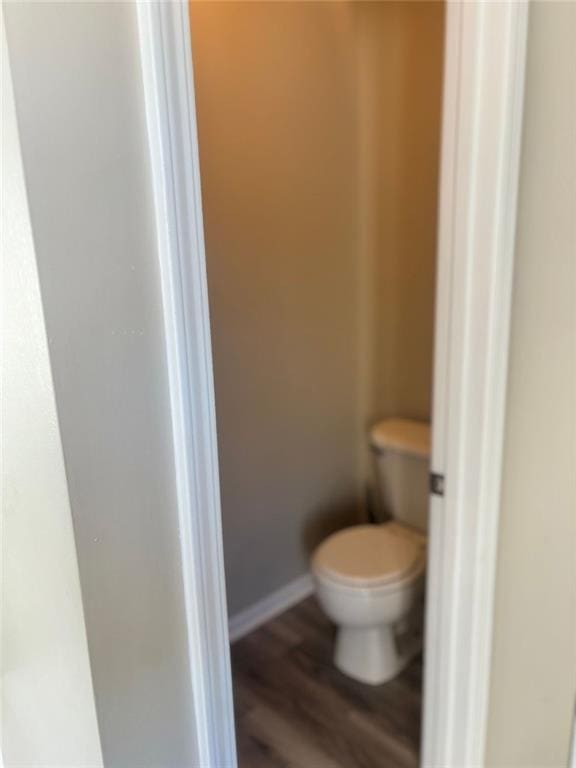 bathroom featuring wood-type flooring and toilet