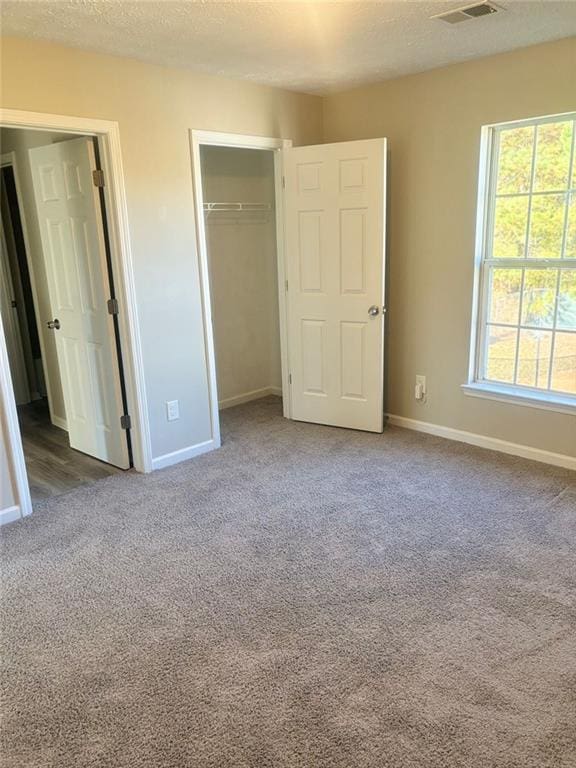 unfurnished bedroom featuring a closet, carpet floors, and a textured ceiling