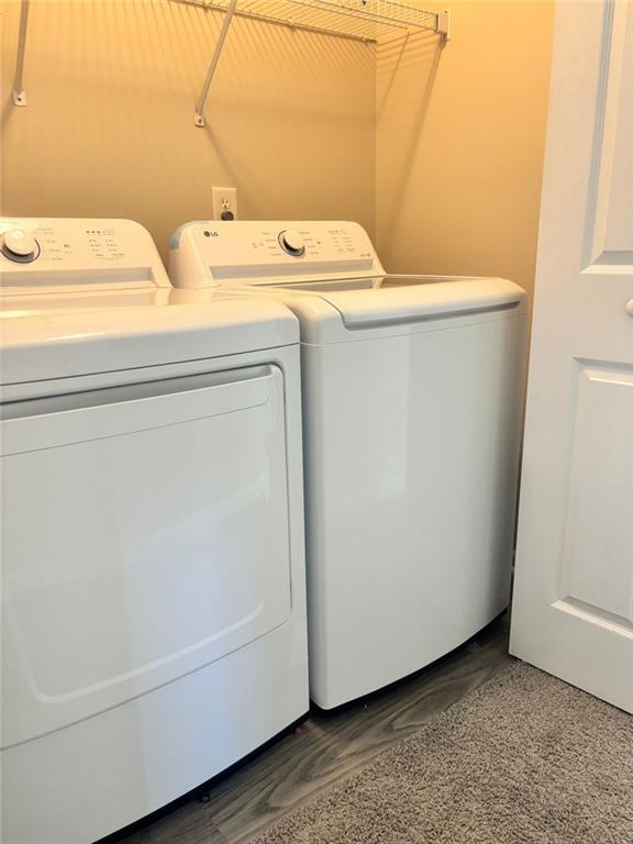 washroom featuring washing machine and clothes dryer and dark hardwood / wood-style flooring