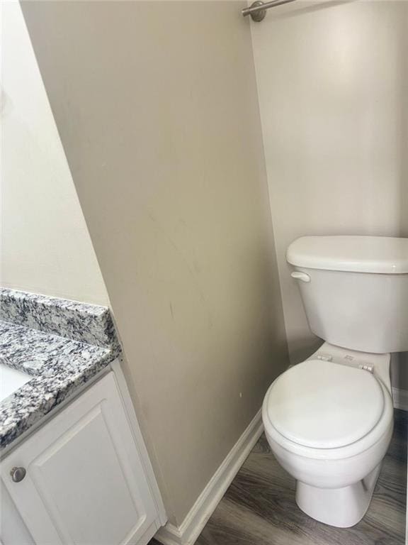 bathroom with hardwood / wood-style flooring, vanity, and toilet