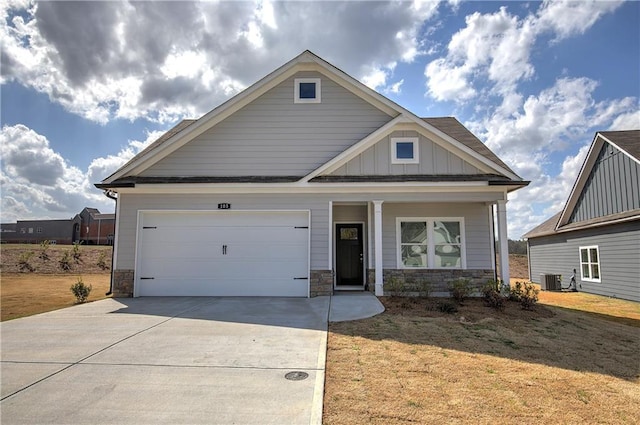 craftsman house featuring stone siding, driveway, an attached garage, and board and batten siding