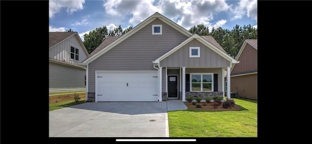 craftsman house with driveway, a front lawn, a garage, stone siding, and board and batten siding