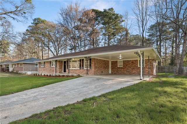 ranch-style house featuring an attached carport, fence, driveway, a front lawn, and brick siding