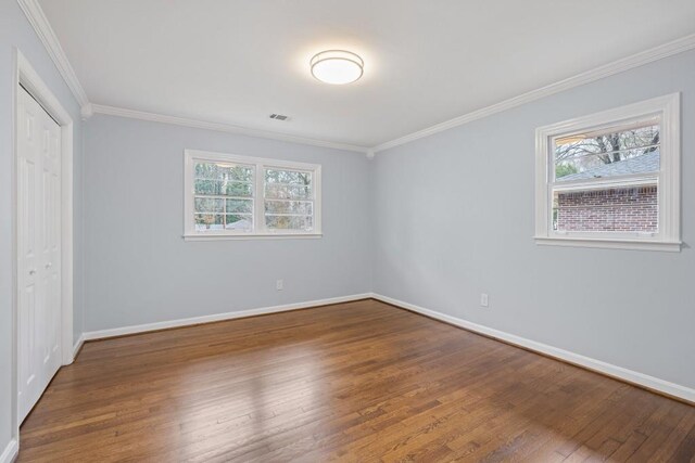 unfurnished bedroom featuring connected bathroom, sink, ornamental molding, dark hardwood / wood-style floors, and a closet