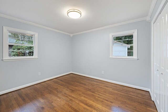 empty room featuring ornamental molding and dark hardwood / wood-style flooring