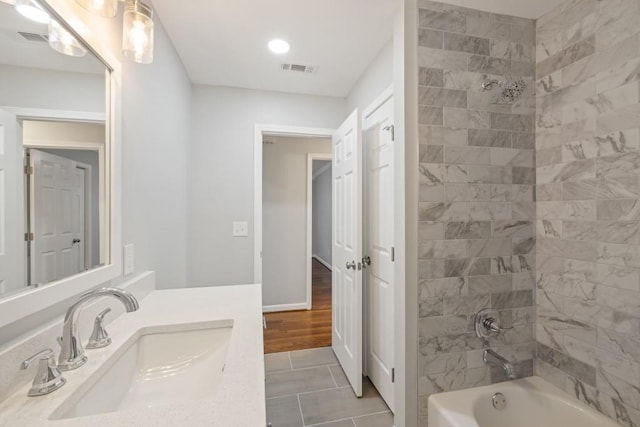 bathroom featuring tile patterned floors, vanity, and tiled shower / bath combo